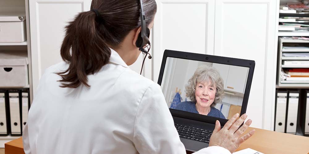 geriatric doctor headset laptop patient